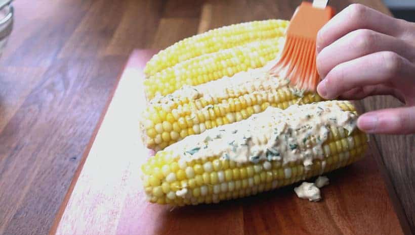 brush cheesy mayo sauce on corn